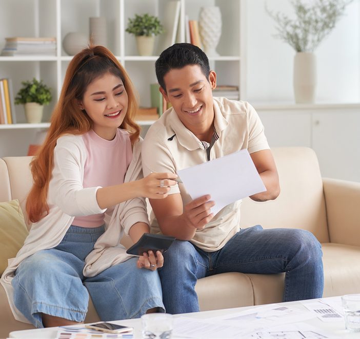 smiley couple looking at the legal loan offer from their go-to Ang Mo Kio money lender, Galaxy Credit, a legal loan company